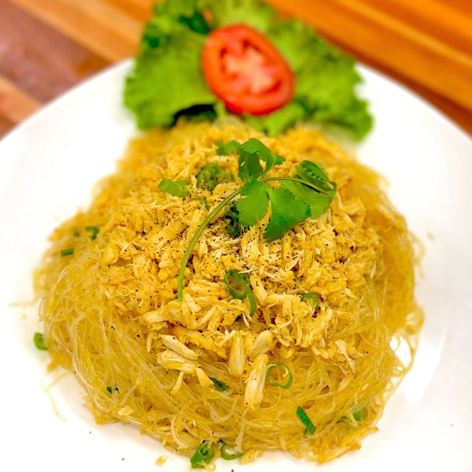 Vietnamese crab and glass noodles, garnished with cilantro, green onions, lettuce, and tomato.